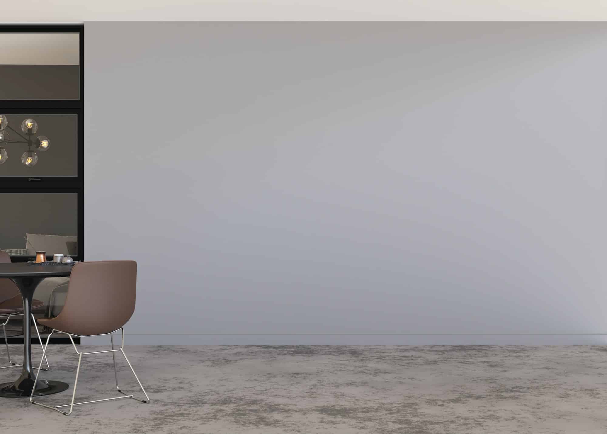 Room with concrete floor, gray wall and empty space. Table with chairs.